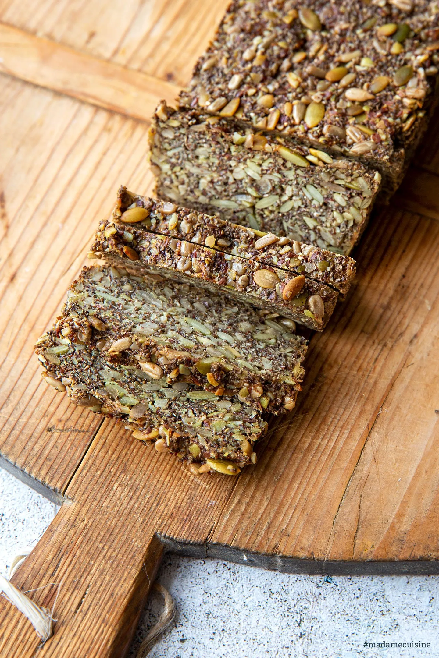 Nahaufnahme einer Scheibe selbst gebackenes Körnerbrot, reich an Saaten und Nüssen