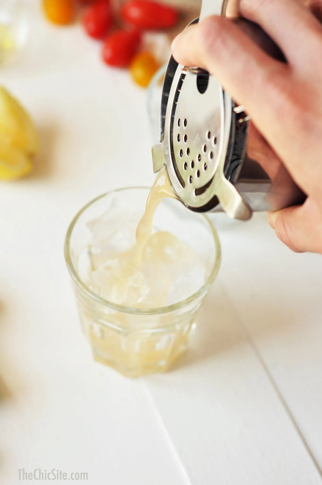 Nahaufnahme eines Cocktails, der in einem Shaker mit Eis geschüttelt wird, wobei die Hände des Barkeepers sichtbar sind