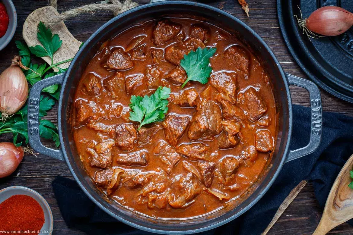 Nahaufnahme eines dampfenden Gulaschs mit Spätzle als Beilage