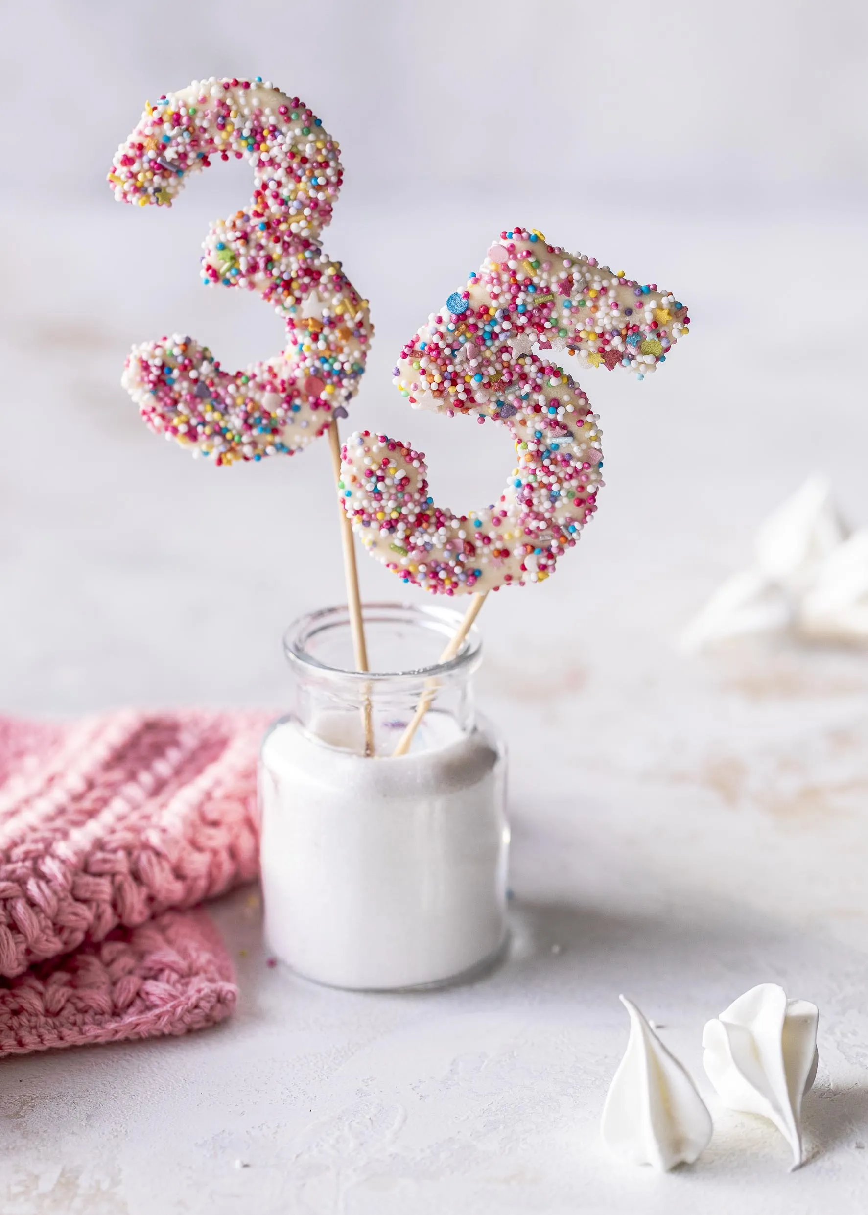 Nahaufnahme eines essbaren Zahlen-Cake-Toppers mit Streuseln auf einer Schokoladentorte