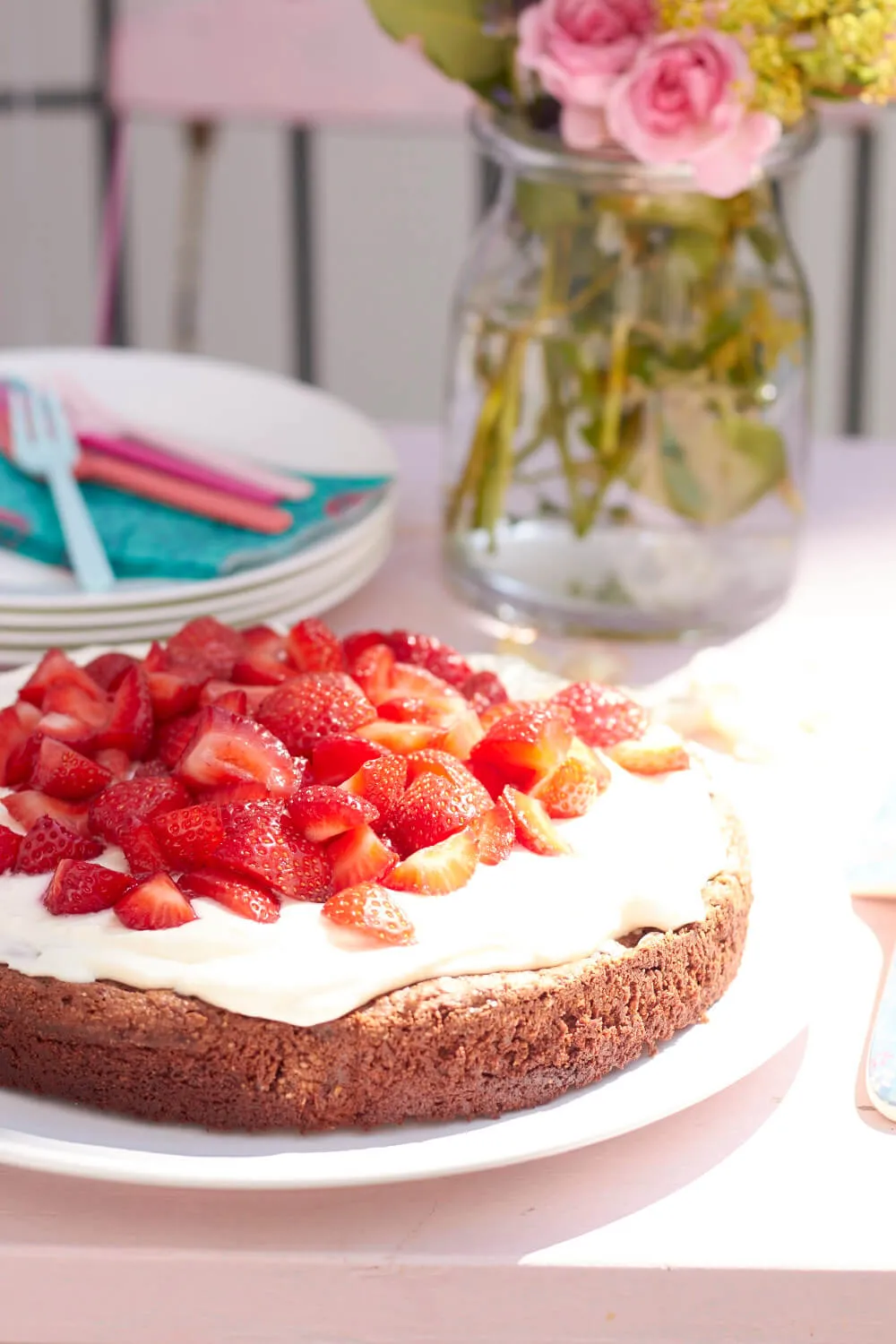 Nahaufnahme eines Schokoladenkuchens mit Sahne und halbierten Erdbeeren, fertig zum Servieren