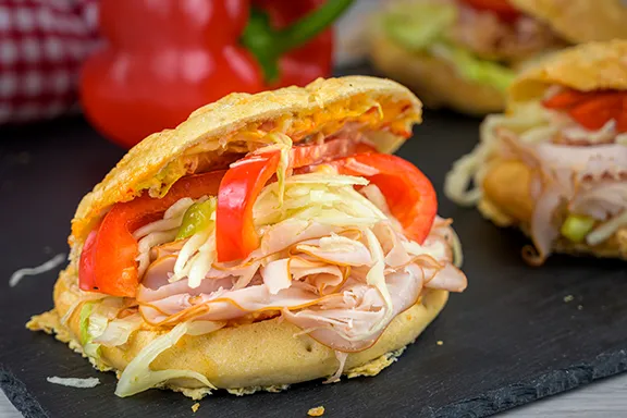 Nahaufnahme von frischen, goldbraunen Brötchen, die zum Verkauf angeboten werden.