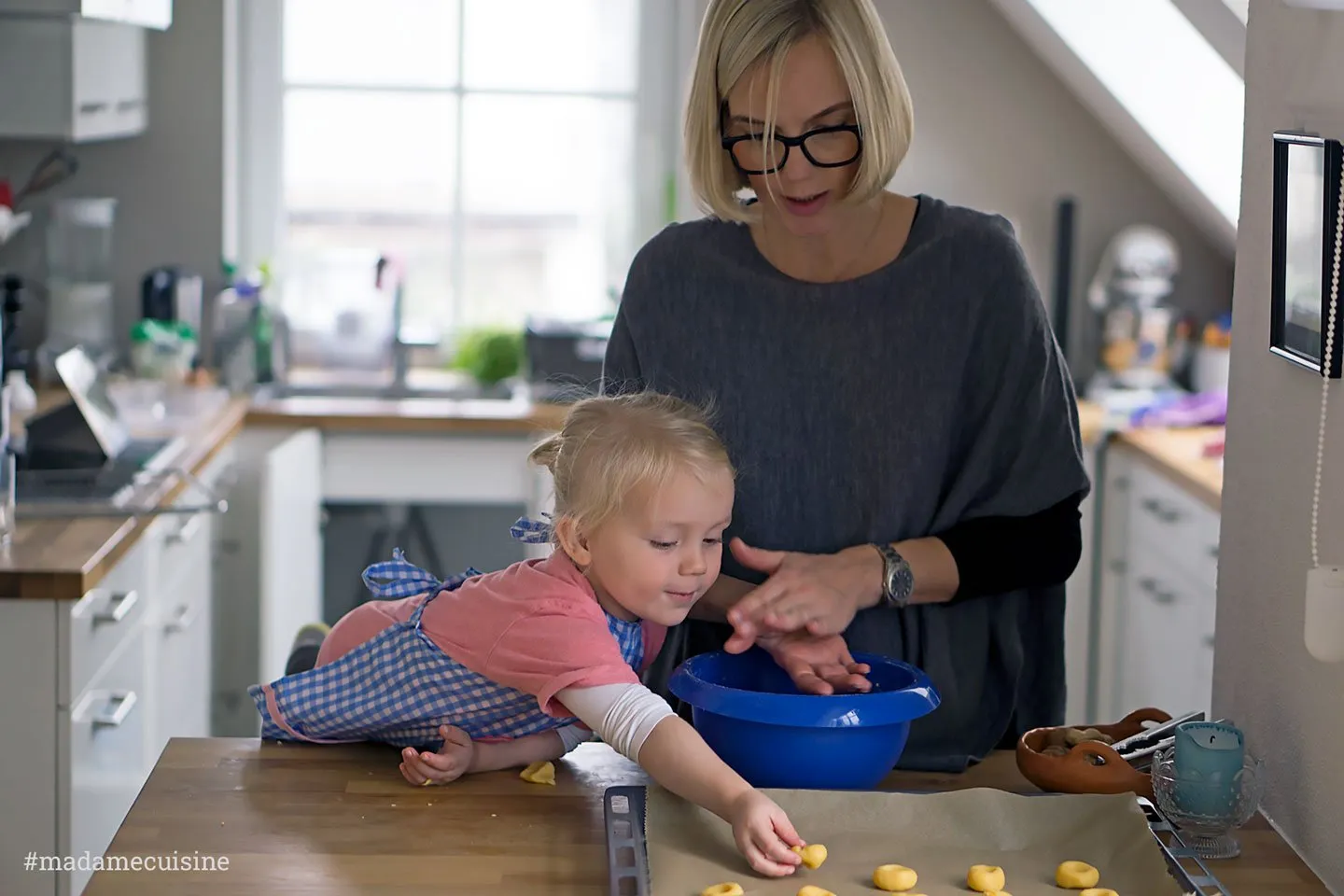 Nahaufnahme von Plätzchen mit Marmelade und Teigkugeln auf Backpapier