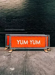 Orangefarbene Banner, die auf dem Bürgersteig stehen.