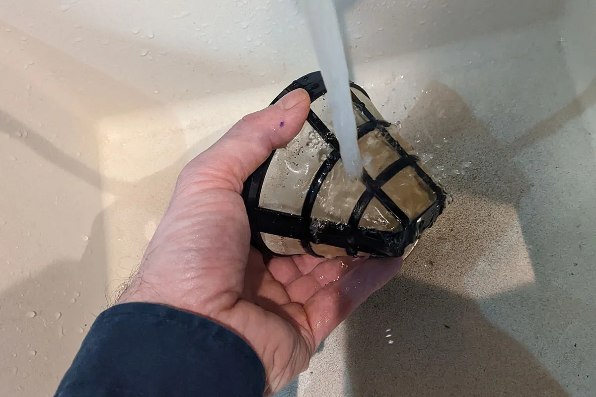 Permanent-Filter wird unter fließendem Wasser gereinigt