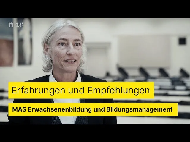 Personen in einem Seminarraum, die auf Bildschirme schauen und diskutieren