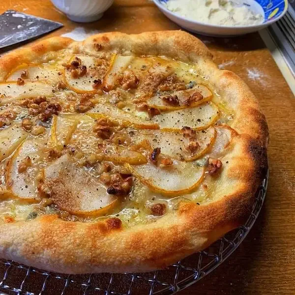 Pizza mit Birne, Büffelmozzarella, Gorgonzola, Walnüssen und Honig für eine süß-salzige Überraschung