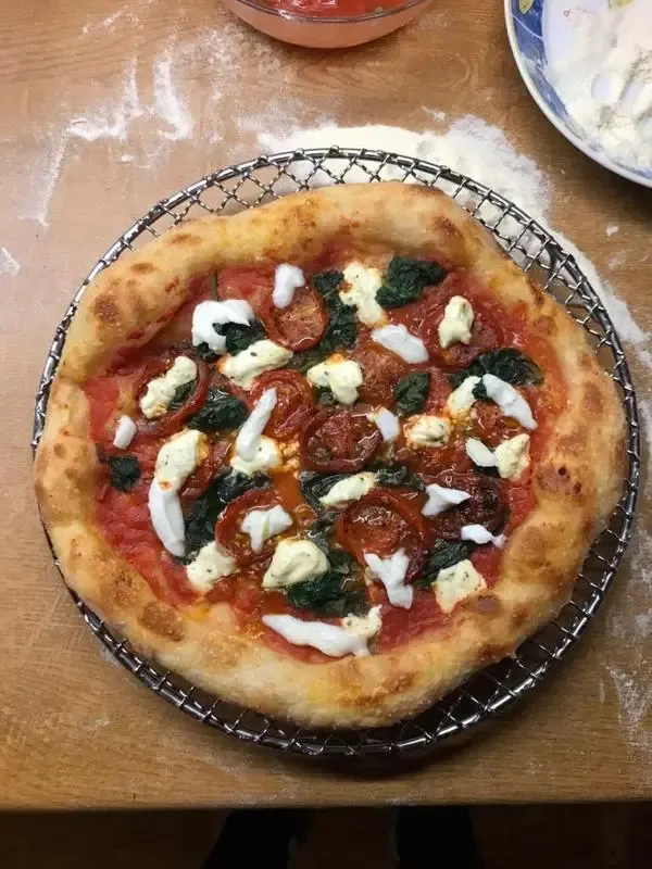 Pizza mit Spinat, marinierten Kirschtomaten und Ricotta für ein ausgewogenes Geschmackserlebnis