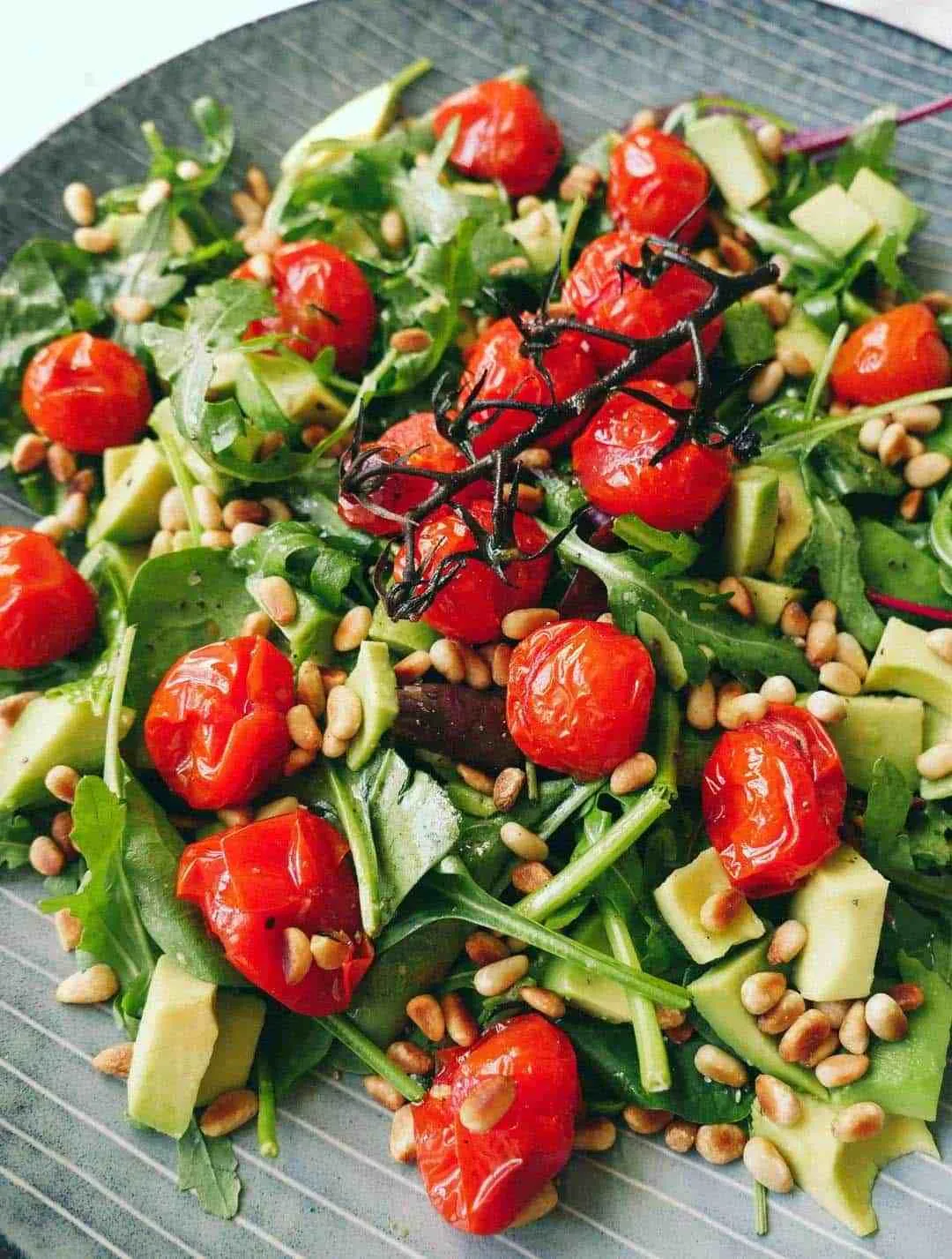 Rucola Salat mit gebackenen Tomaten in Nahaufnahme, verlockend und frisch