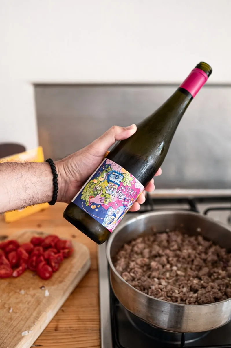 Salsiccia-Ragout köchelt in der Pfanne mit Tomaten und Kräutern