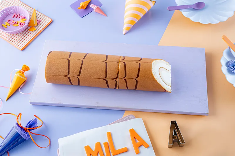 Schräges Anschneiden der Sahnerolle zur Stiftspitze.