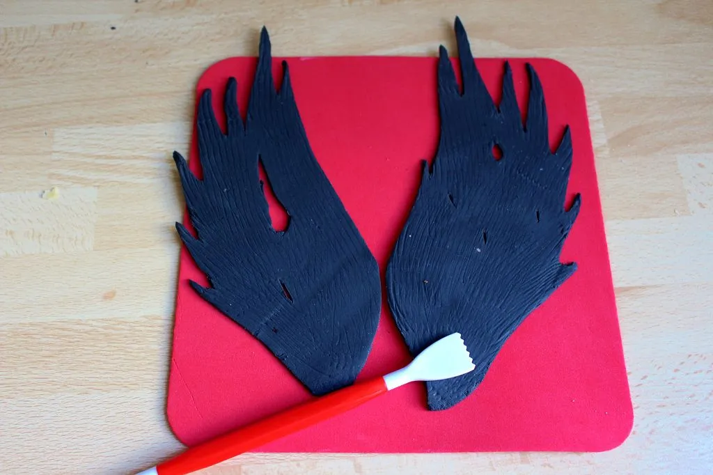 Schwarze Fondantflügel, gehärtet mit Blütenpaste, auf Holzspießen