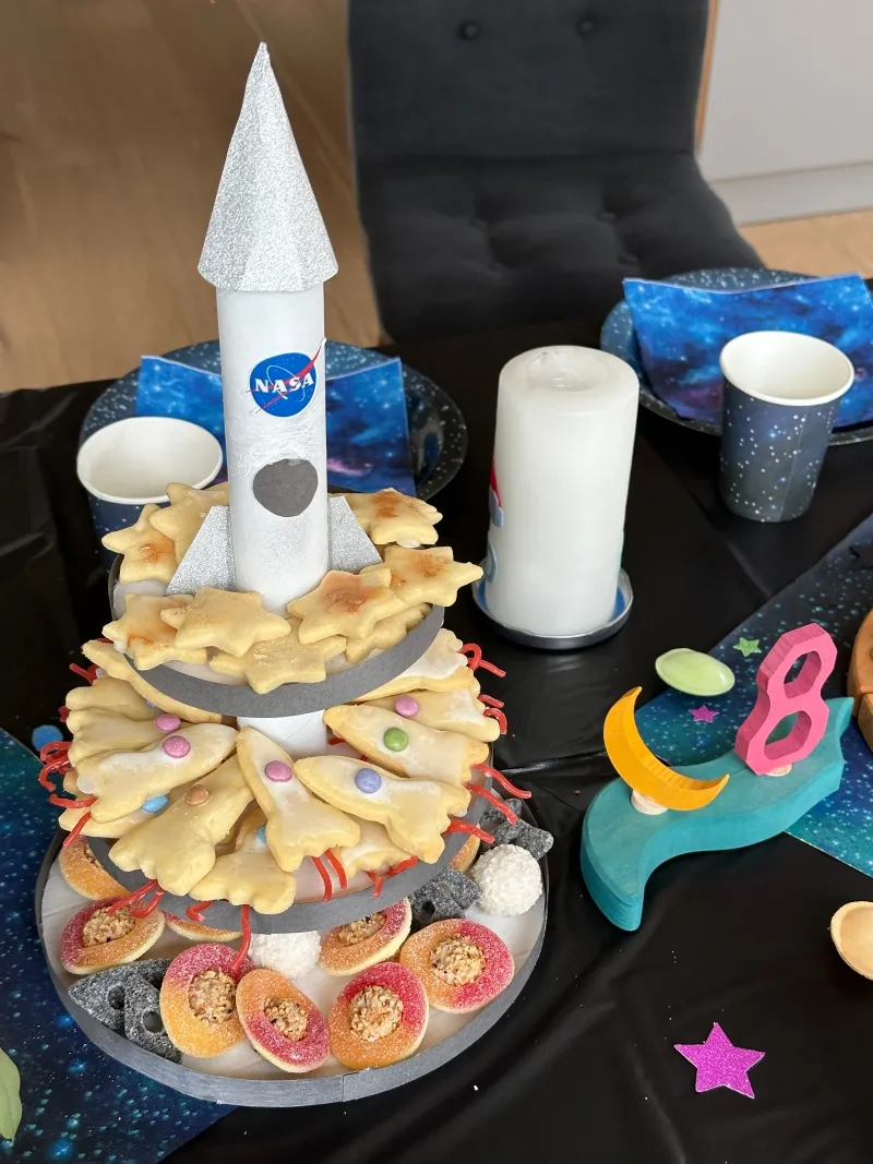 Selbstgemachte Raketen-Kekse mit Zuckerguss und essbarem Glitter, bereit zum Verzehr.