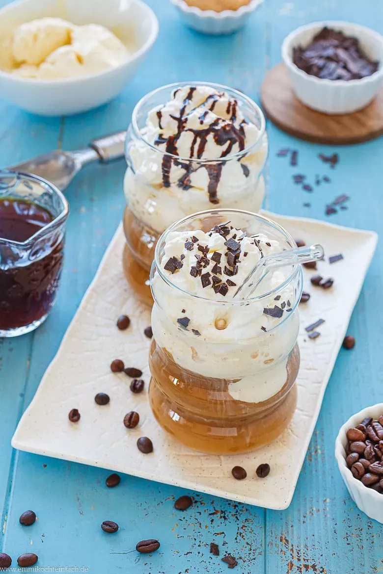 Selbstgemachter Eiskaffee in hohen Gläsern, gekrönt mit Sahne und Schokoraspeln