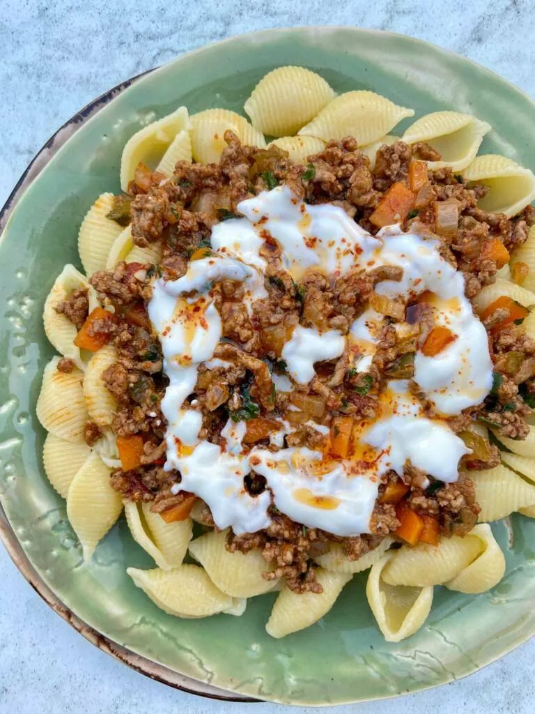 Servierfertiges Cheat Manti mit Hackfleischsauce, Knoblauchjoghurt und Pul Biber Öl