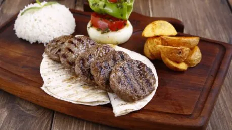 Servierte Köfte auf Fladenbrot mit frischen Beilagen