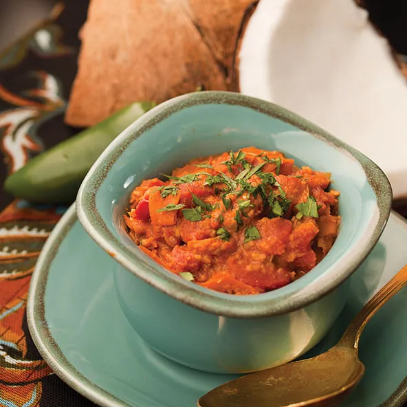 Servierte Schale mit einer reichhaltigen und cremigen südindischen Currysauce, garniert mit frischen Kräutern