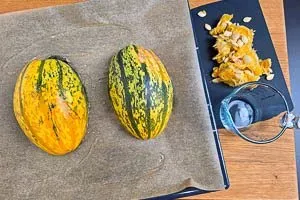 Spaghettikürbis halbieren und mit Wasser befüllen, in den Ofen geben