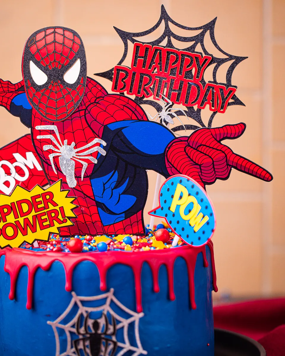 Spiderman Torte mit roten und blauen Elementen, dekoriert mit Streuseln und Cake Toppern.