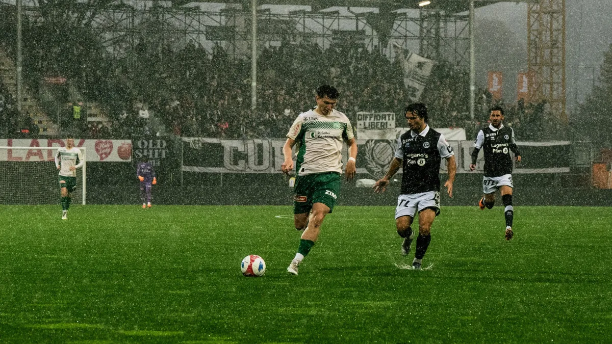 Spieler des FC St. Gallen in Aktion während eines Heimspiels mit voller Tribüne im Hintergrund.