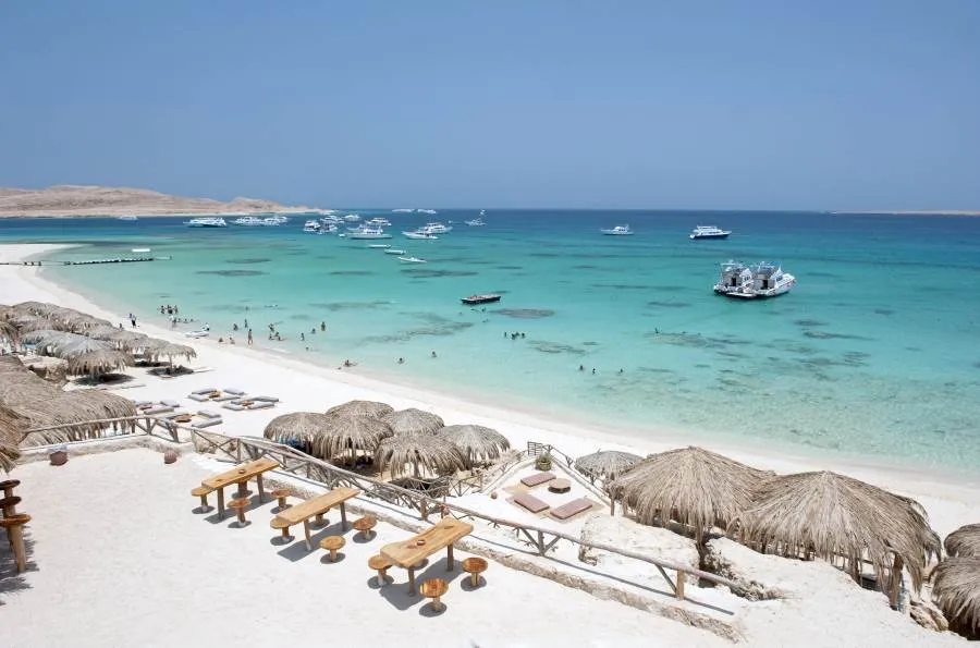 Strand in Hurghada mit klarem blauen Wasser und Sonnenschirmen
