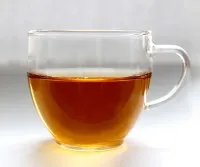 Tasse mit Kräutertee gegen Magenschmerzen und Bauchkrämpfe