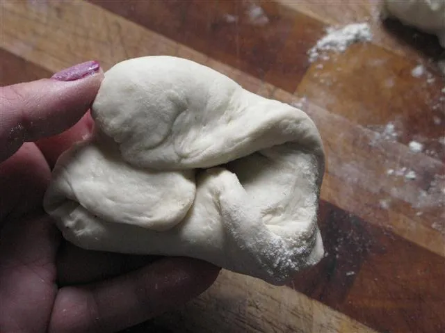 Teiglinge werden von Hand zu runden Brötchen geformt
