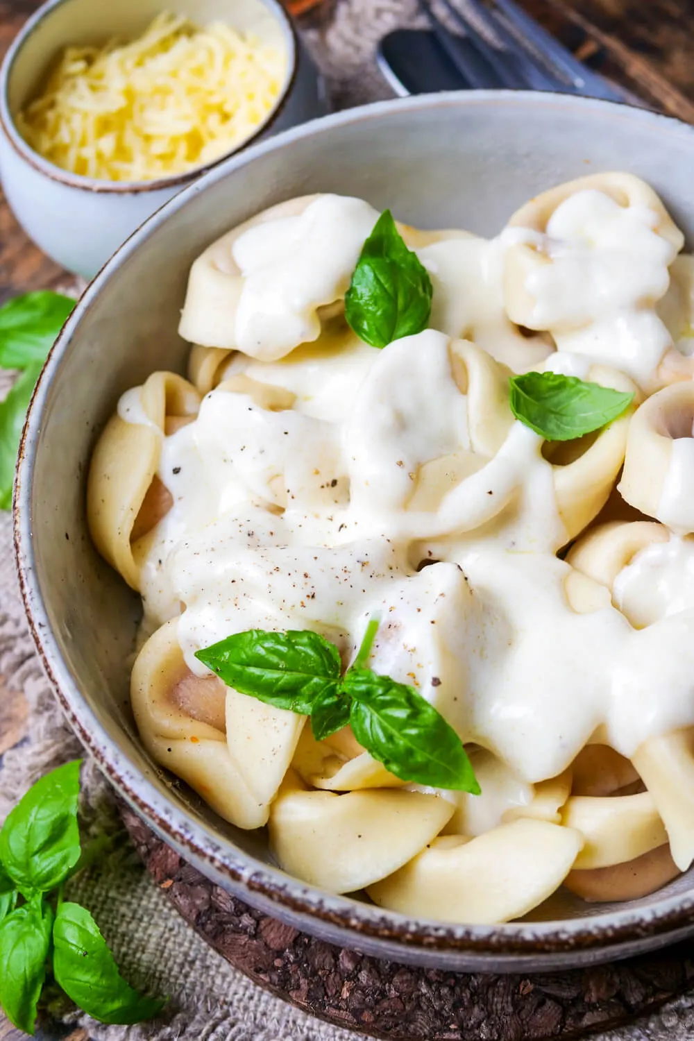 Teller mit Tortellini und reichlich cremiger Käsesoße