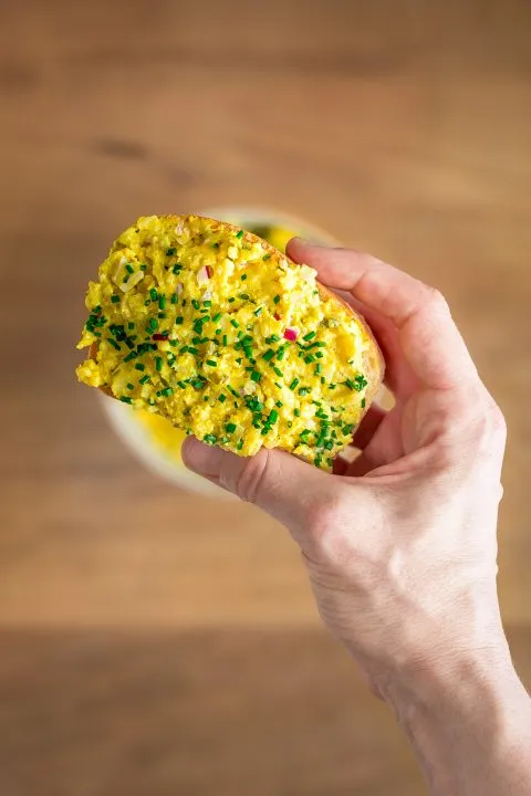 Teller mit veganem Eiaufstrich und frischen Kräutern als Garnitur