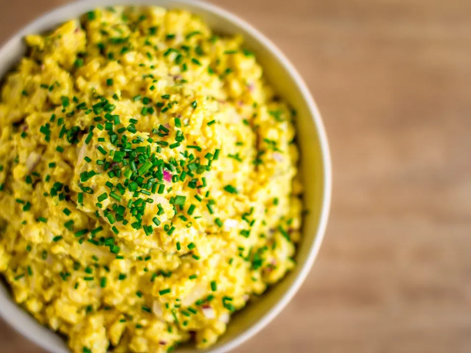 Veganer Eiaufstrich mit Kichererbsen und Nudeln in einer Holzschale angerichtet