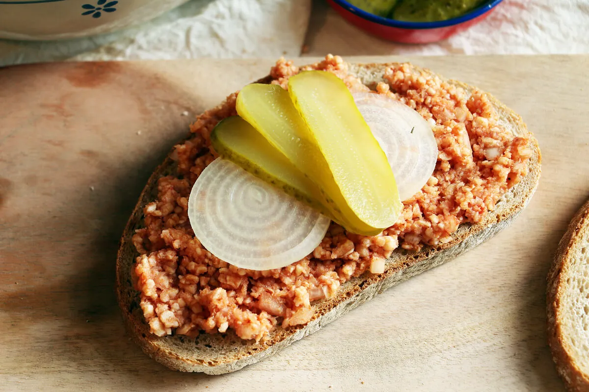 Veganes Mett als Brotaufstrich auf Brot mit frischen Zwiebelringen