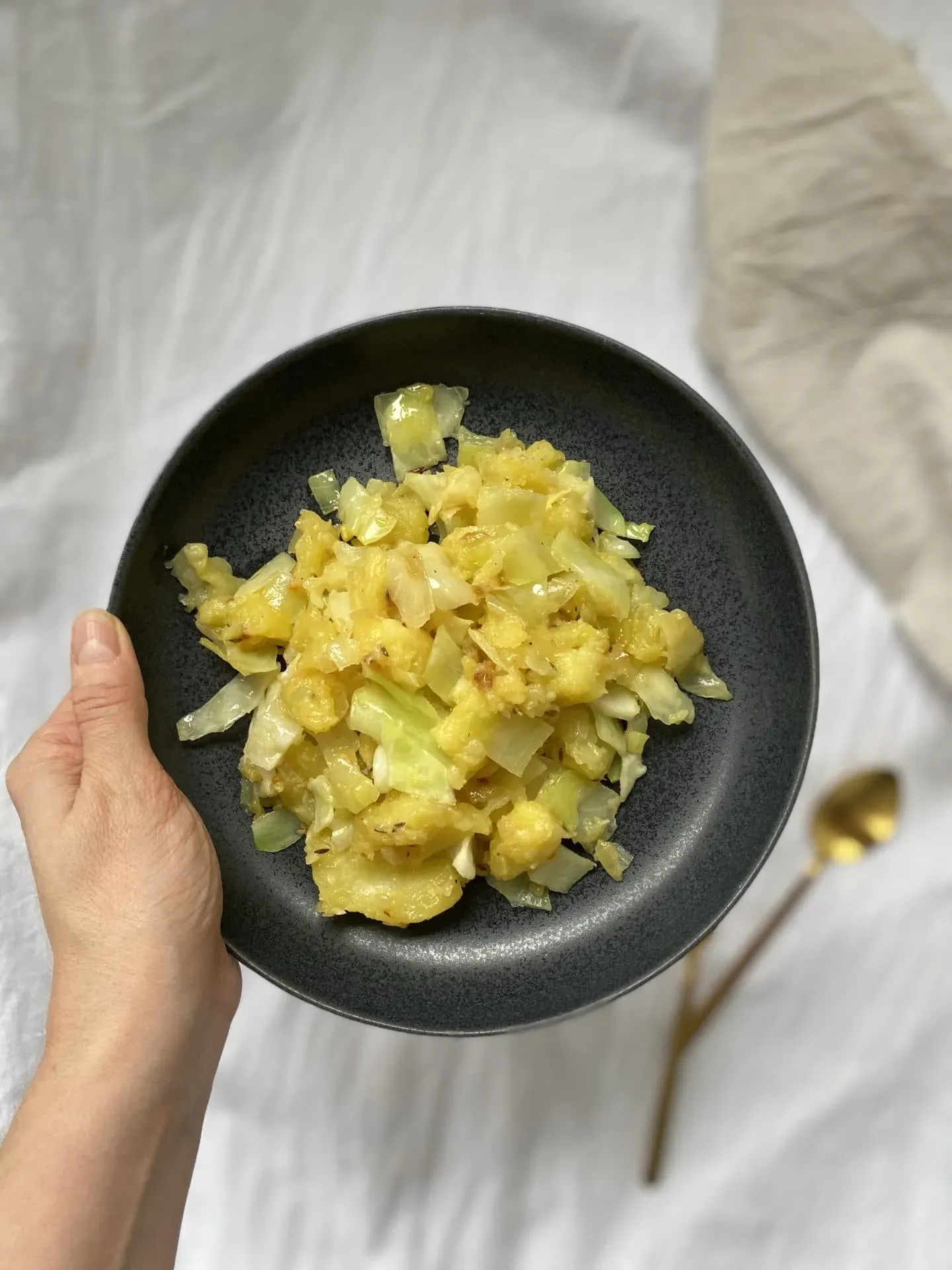 Vegetarische Kartoffel-Kraut-Pfanne, frisch zubereitet mit golden gebratenen Kartoffeln und zartem Kraut