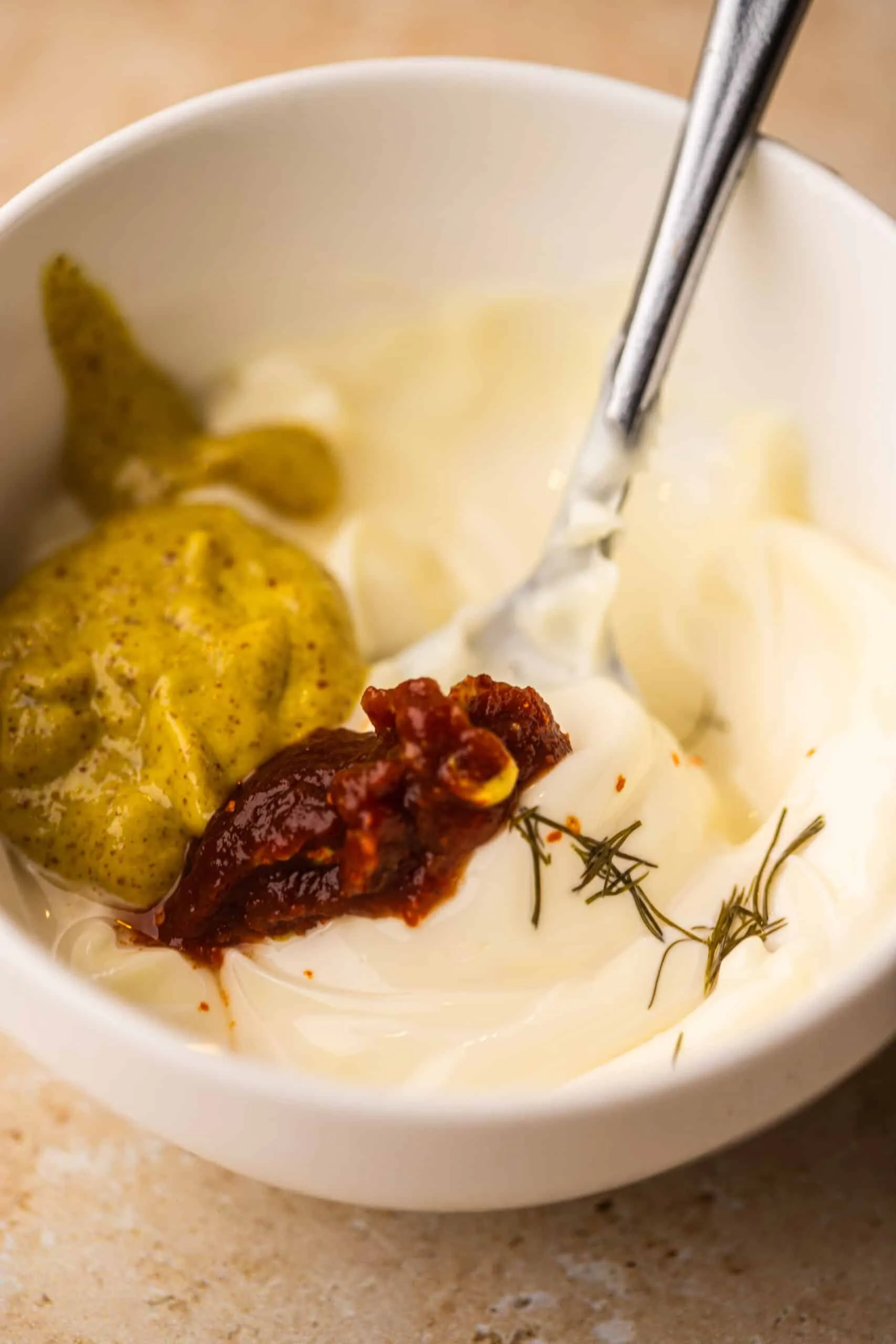 Verschiedene Gewürze werden in einer kleinen Schüssel mit einem Löffel vermischt.