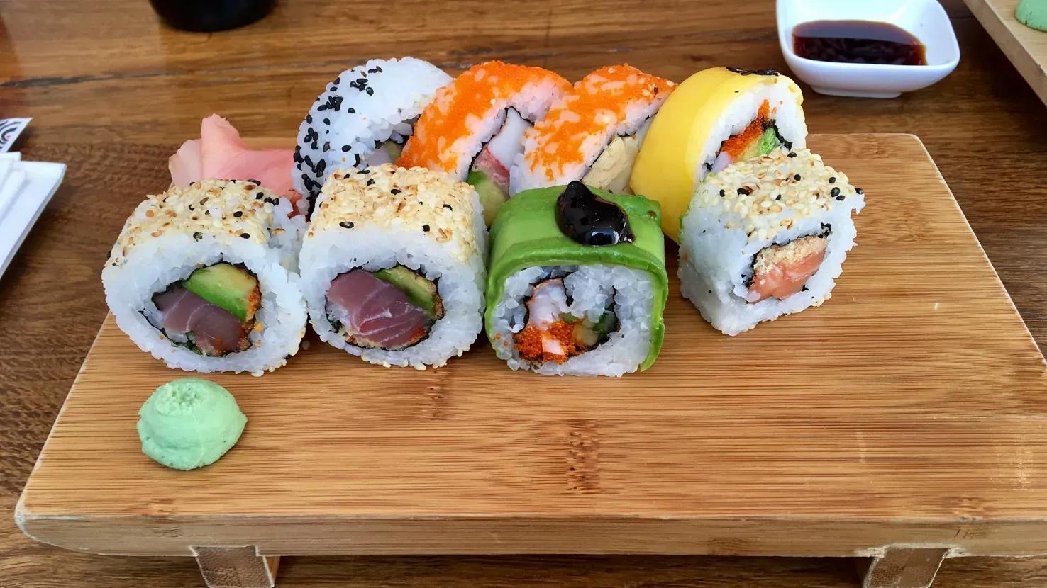 Verschiedene Sushi-Rollen mit Reis und Nori-Algen, gefüllt mit frischen Zutaten, appetitlich angerichtet.