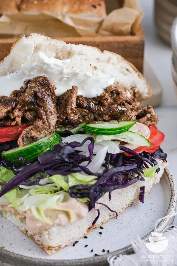 Verschiedene Zutaten für den selbstgemachten Kebab, darunter Fleisch, Gemüse und Saucen