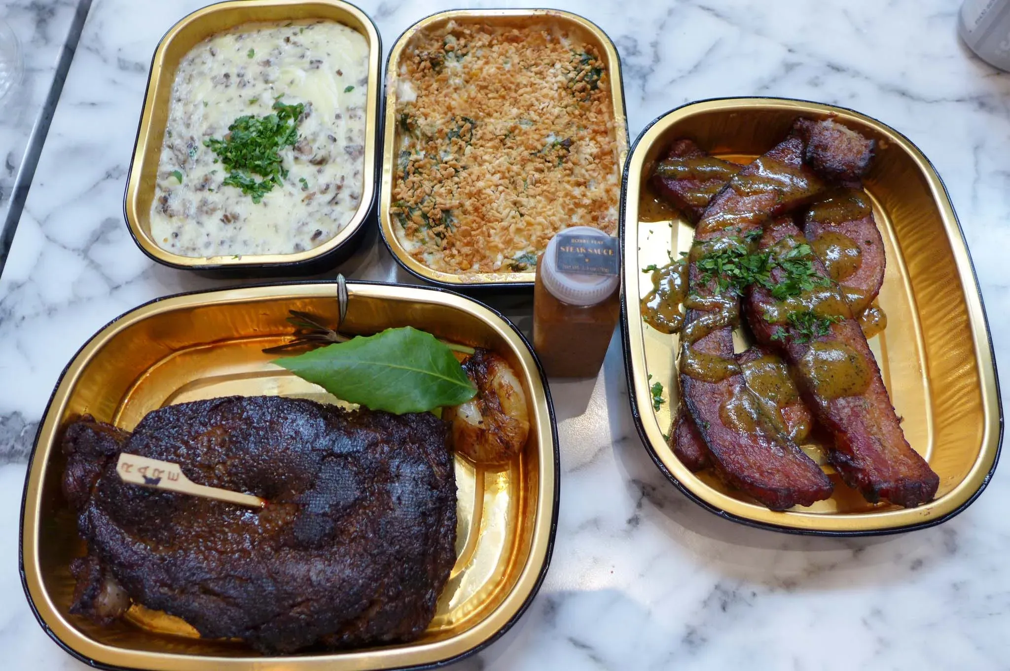 Vier Abholbehälter auf einer Marmoroberfläche.