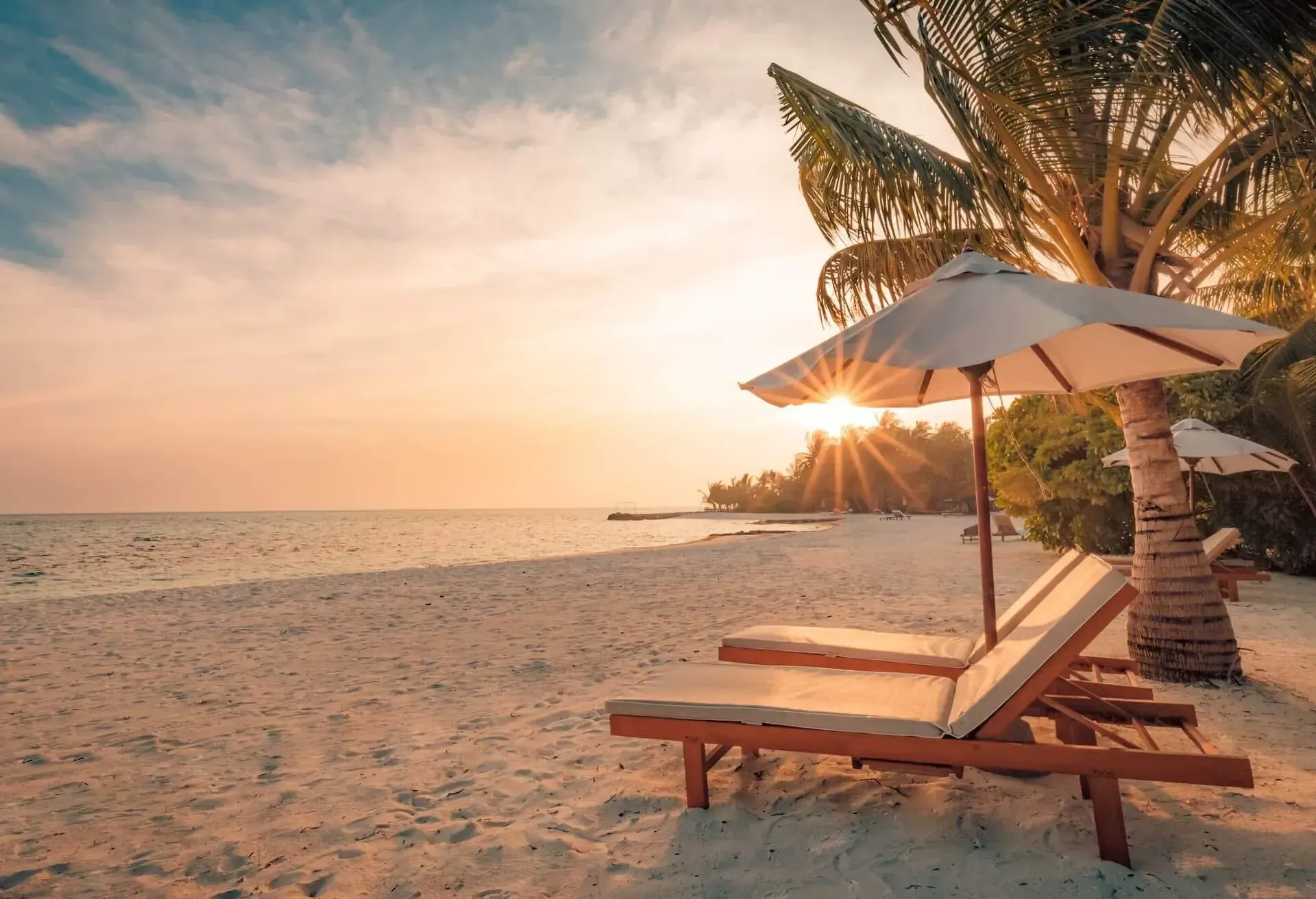 Weißer Sandstrand mit Liegen und Schirm auf den Bahamas