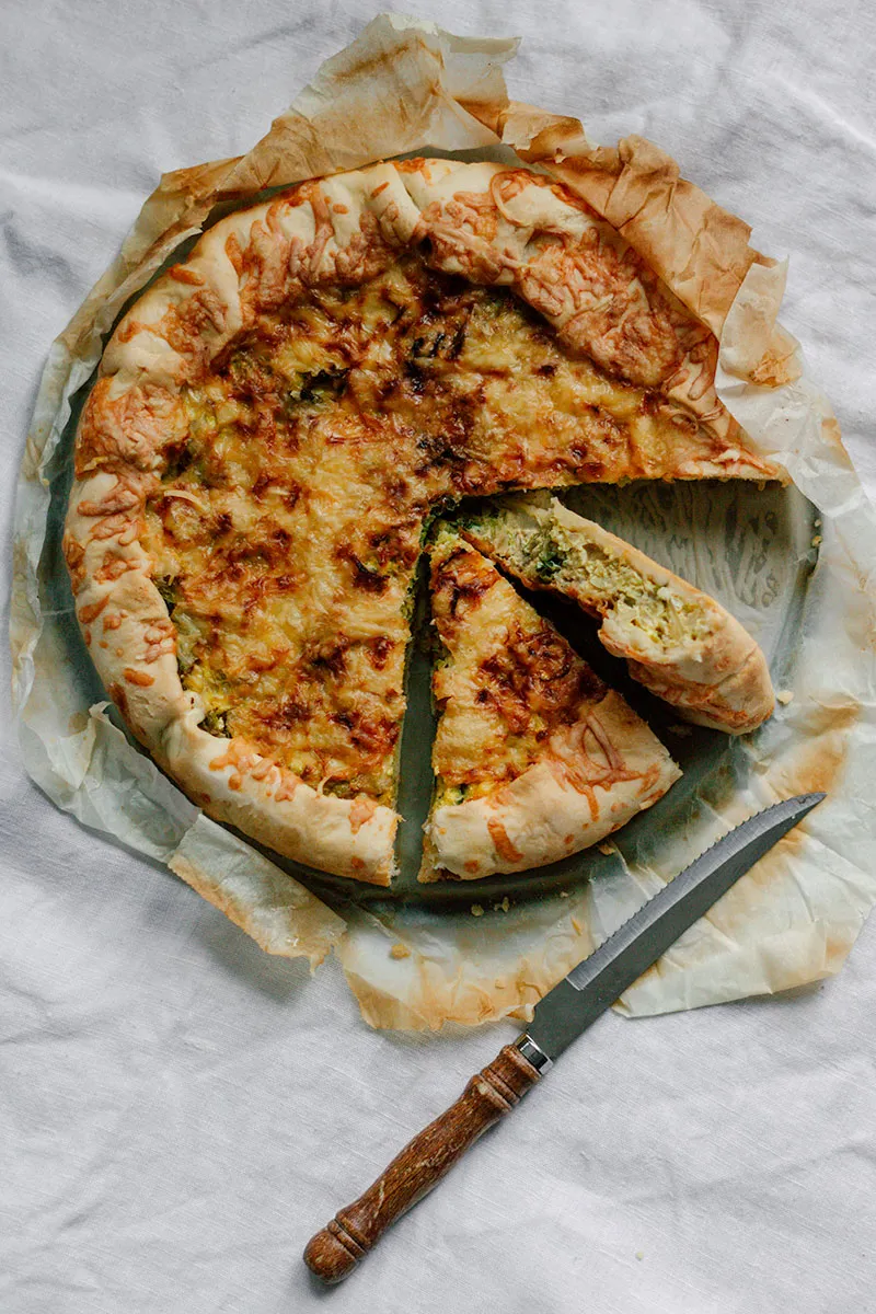 Wirsing-Tarte vor dem Backen mit frischen Wirsingblättern als Dekoration