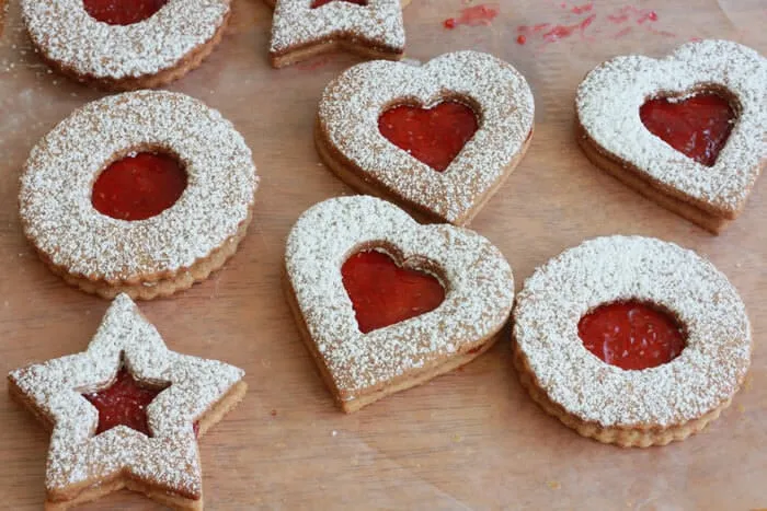 Wunderschön angerichtete Linzer Plätzchen mit Himbeermarmeladenfüllung auf einem weißen Teller