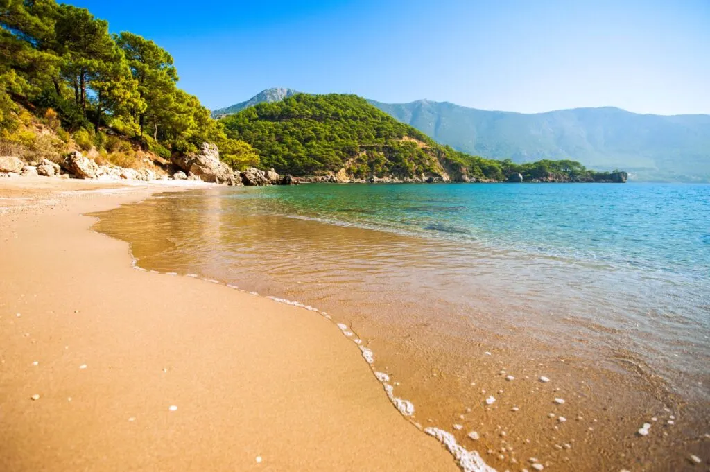 Wunderschöner Sandstrand an der türkischen Riviera mit Sonnenschirmen und blauem Meer