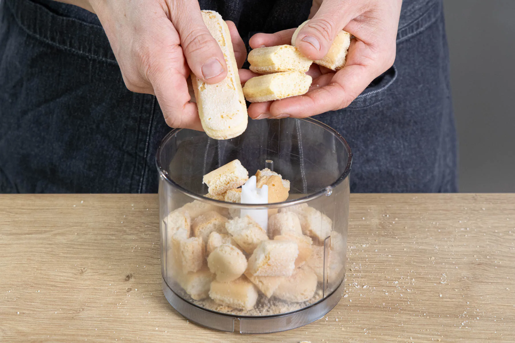 Zerkleinerter Löffelbiskuit in einem Mixer für den Tortenboden