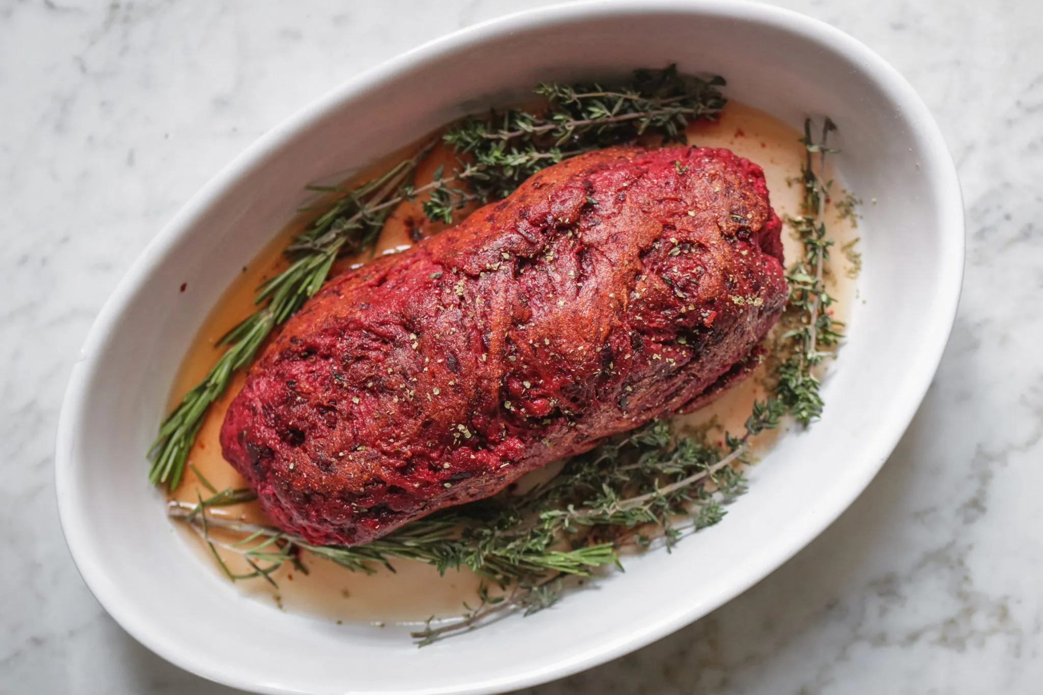 Zubereitungsschritt: Der Braten wird mit Brühe übergossen