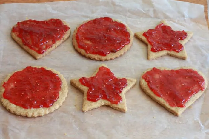 Zubereitungsschritt: Unterhälften der Linzer Plätzchen werden mit Himbeermarmelade bestrichen