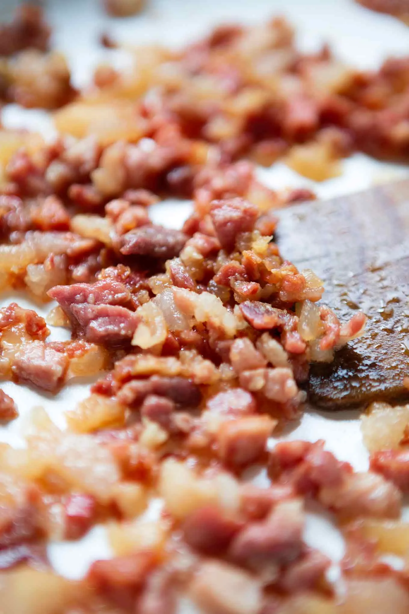 Zutaten für Carbonara, darunter Eier, Speck und Parmesan, auf einer Arbeitsfläche.