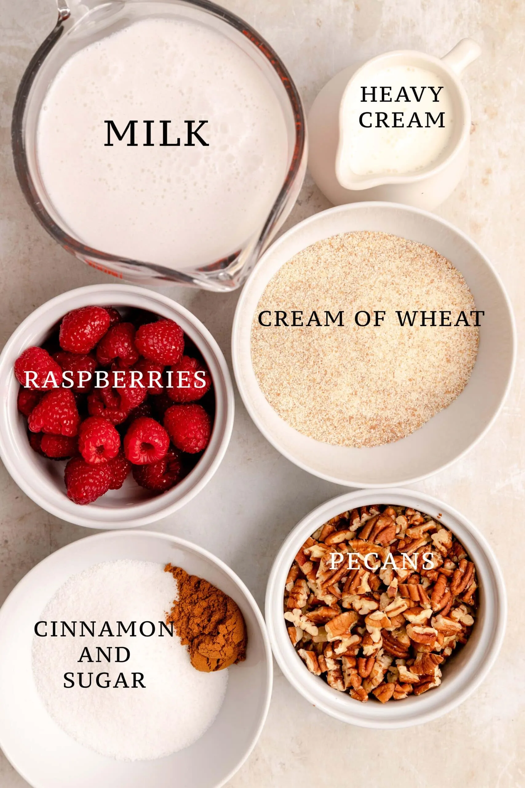 Zutaten für Grießbrei und verschiedene Toppings auf einem hellen Hintergrund, einschließlich Milch, Weichweizengrieß, Beeren, Nüssen und Zimt.