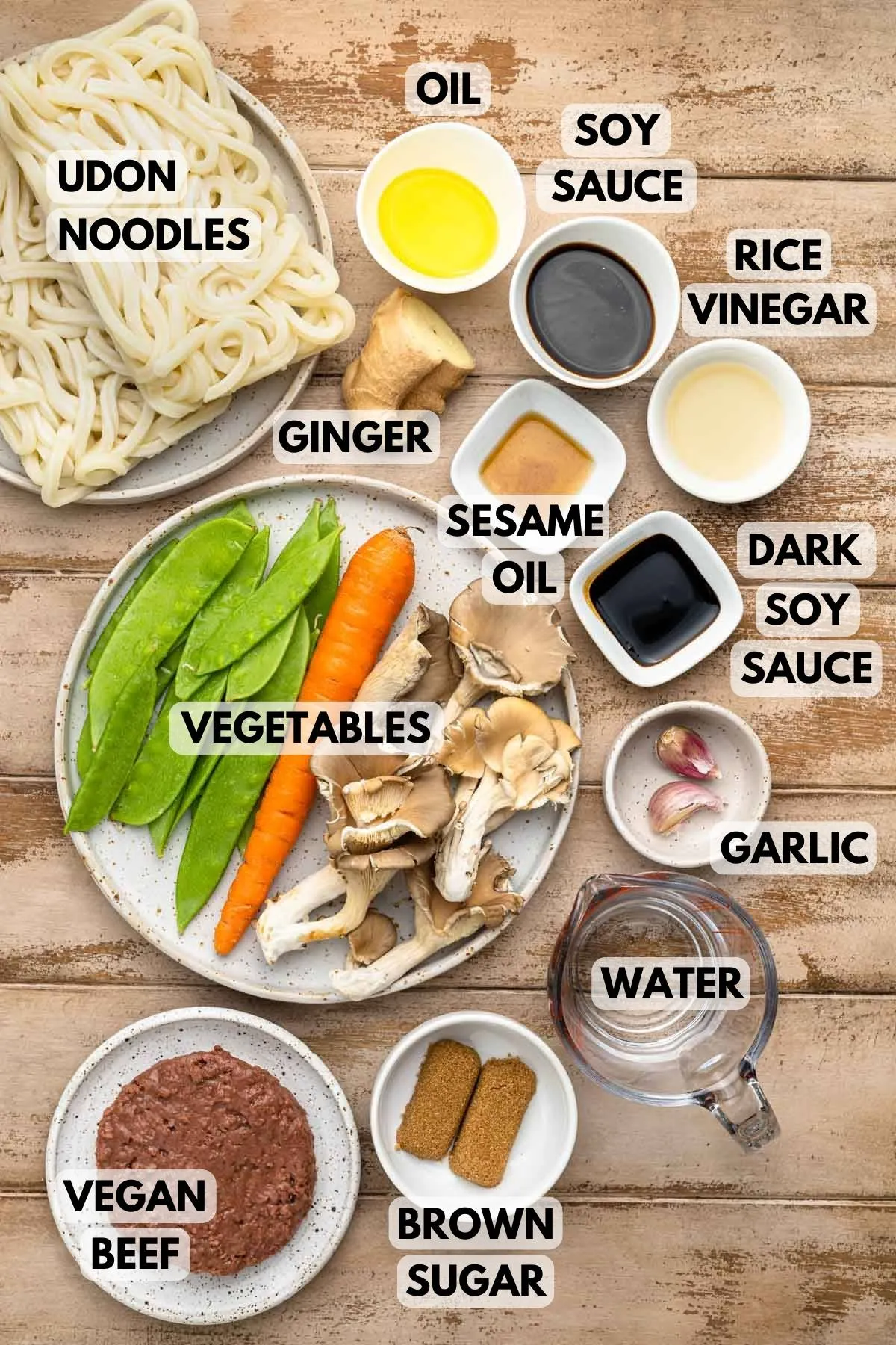 Zutaten für Teriyaki Udon Nudeln, ausgebreitet auf einer Holzplatte