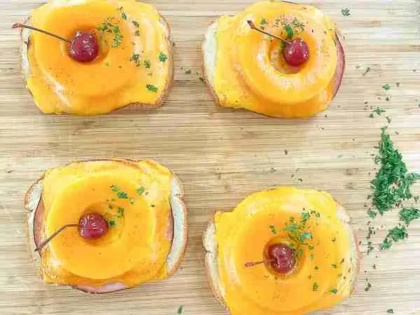 Zutaten für Toast Hawaii bereitgelegt, einschließlich Toastbrot, Ananas, Schinken und Käse.