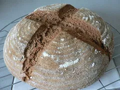 Zwei frisch gebackene, runde Weizenvollkornbrote mit einer knusprigen Kruste