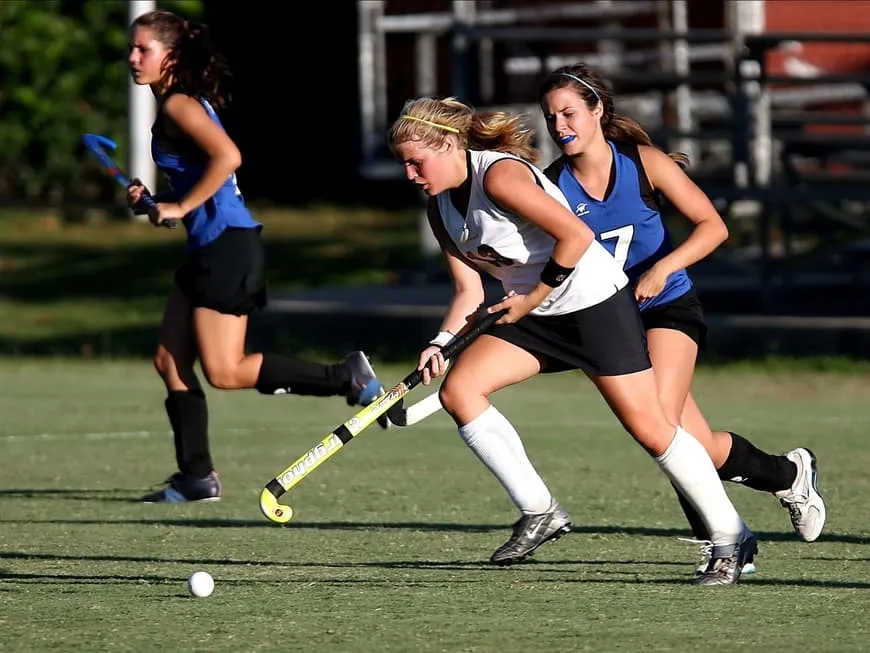 Zwei Hockey-Spielerinnen im Zweikampf auf einem Rasenfeld