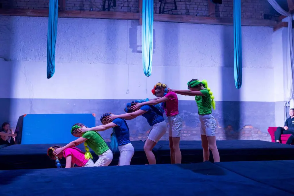 Zwei junge Frauen üben eine komplexe Figur am Vertikaltuch während einer Zirkusscheunen-Show